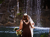 big-island-hawaii > Bride and maids in front of waterfall in Waikoloa Village